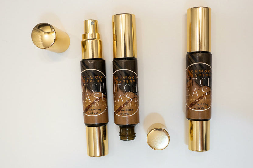 Three bottles of 'Itch Ease' with gold caps on a white background