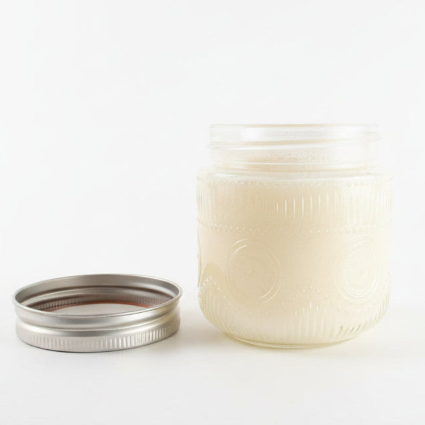 White jar with a silver lid on a white background