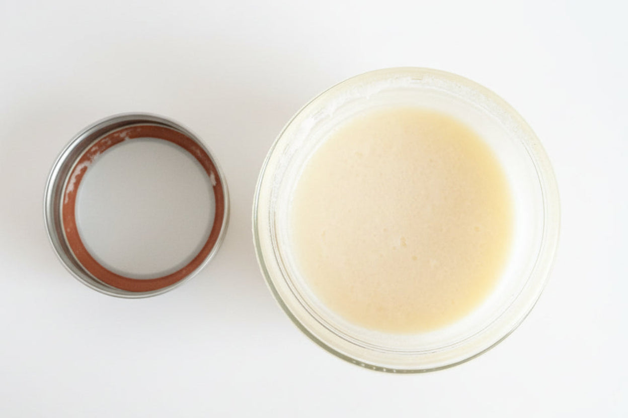 Jar of cream with a metal lid on a white background